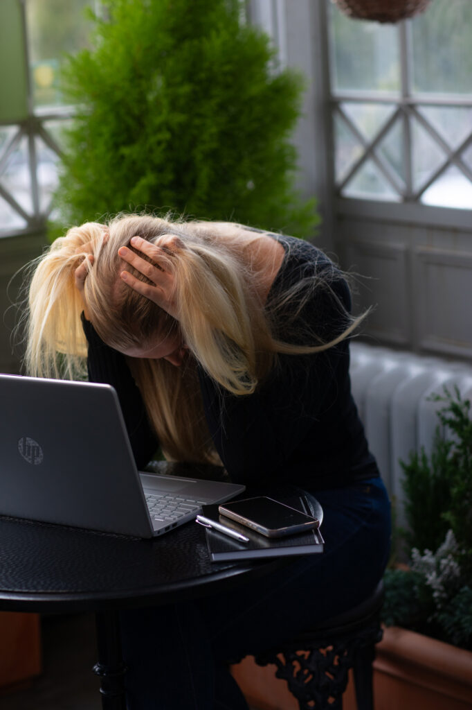 Stressin oireet – nainen hieroo päätään